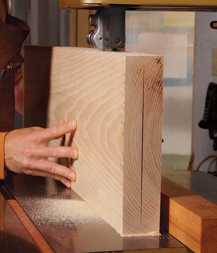 A bandsaw cutting a wide piece of wood