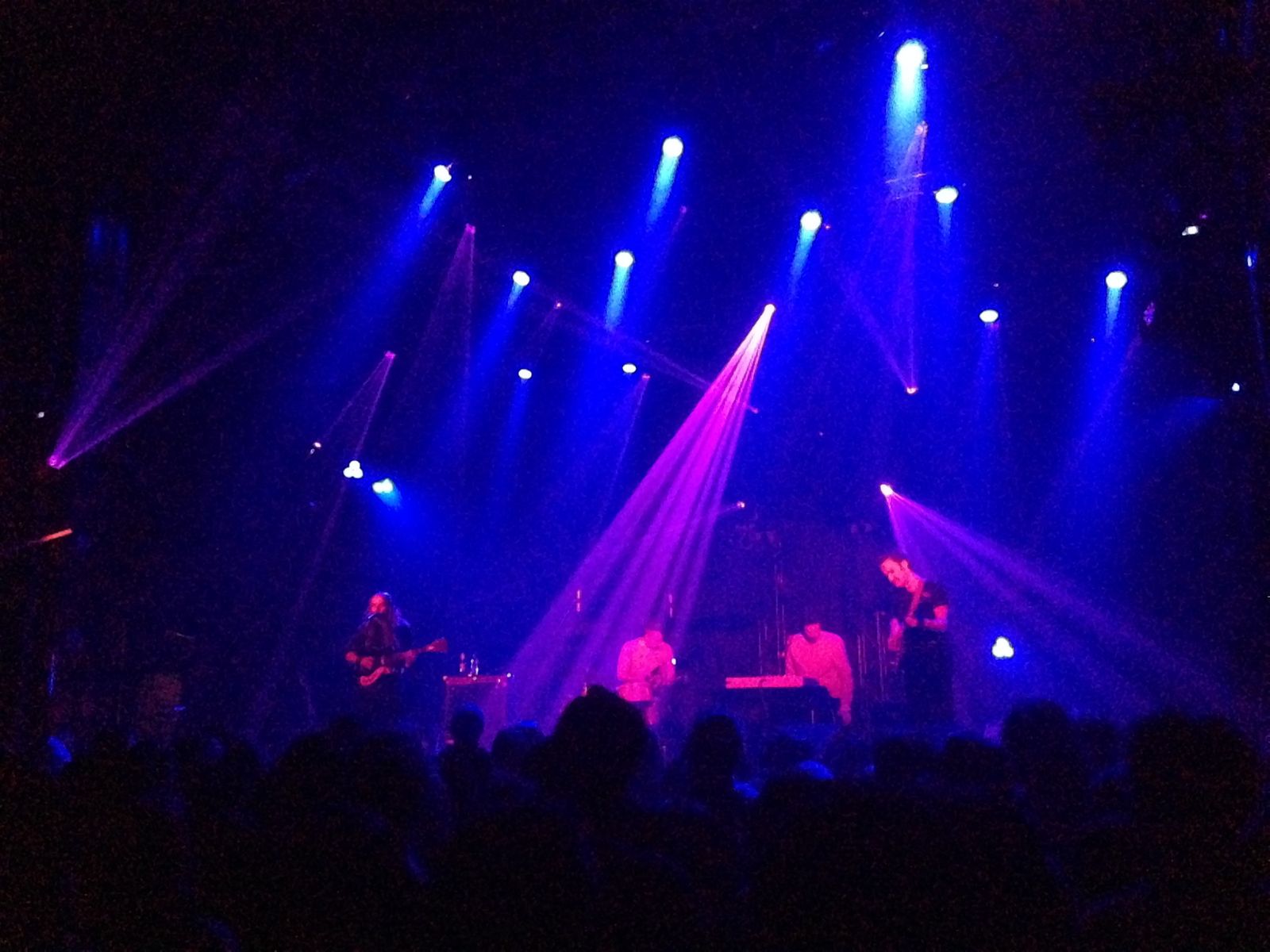 Blurry photo of Andy and his band in a venu photographed from the back