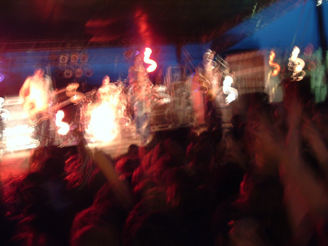 Brand New performing in a dark club with motion-blurred stage lights