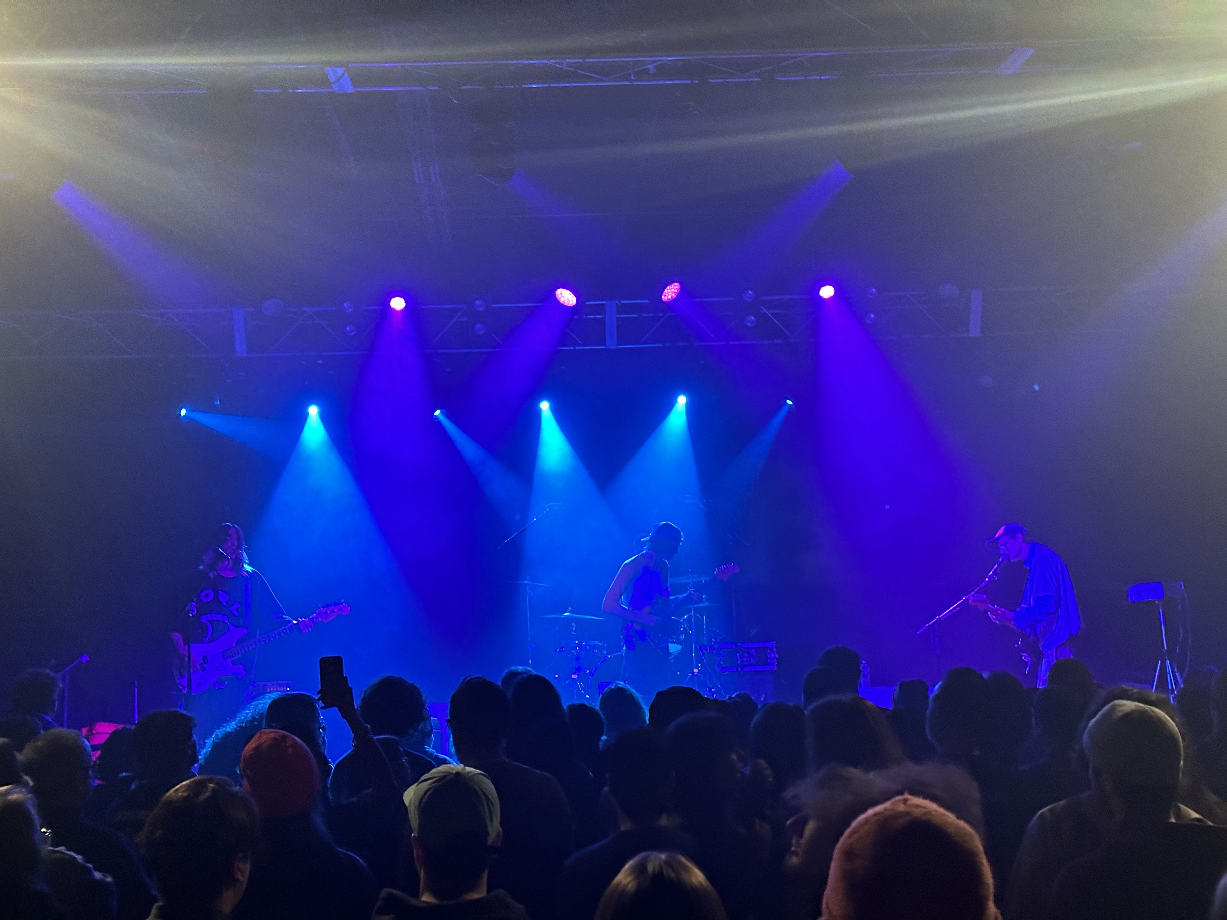 Dark photo of DIIV in pale blue light at Higher Ground in 2023