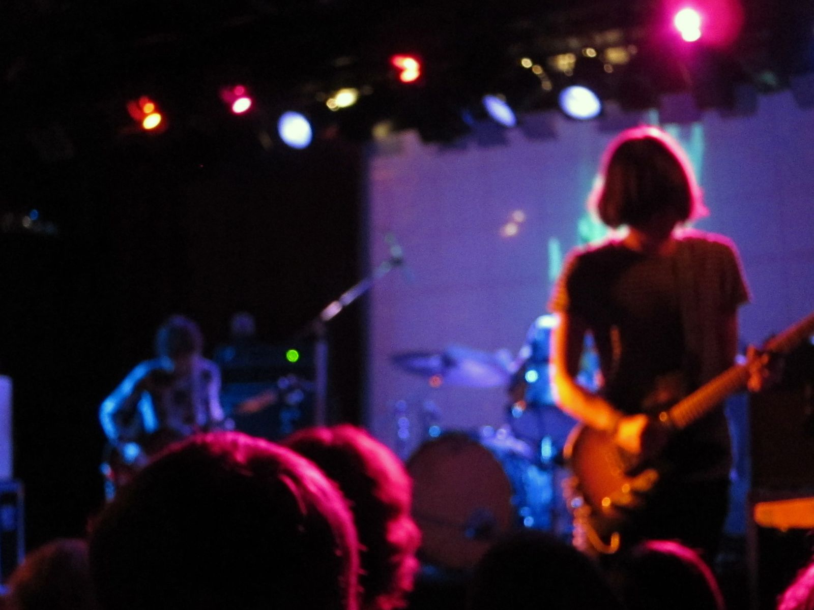 Tame Impala guitarist with back to crowd, band bathed in pink and blue stage lights at the Paradise Rock Club in Boston