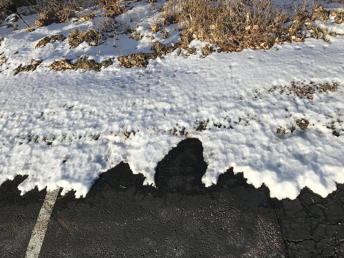  abstract shapes of a parking lot, snow edge, and dried grass