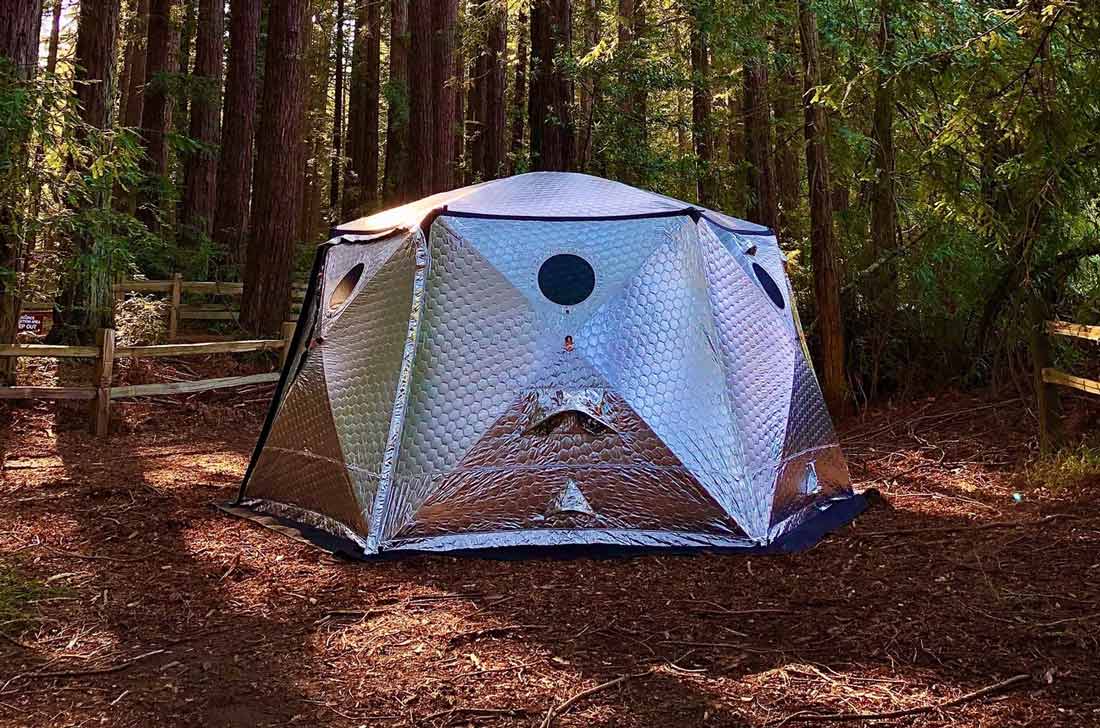  in a metallic, hexagonal, futuristic-looking tent in the middle of a forest