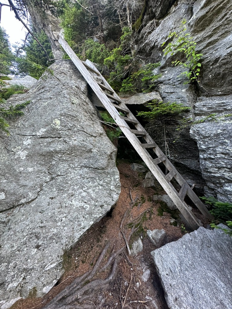 Wooden ladder wedged into a narrow granite crevice